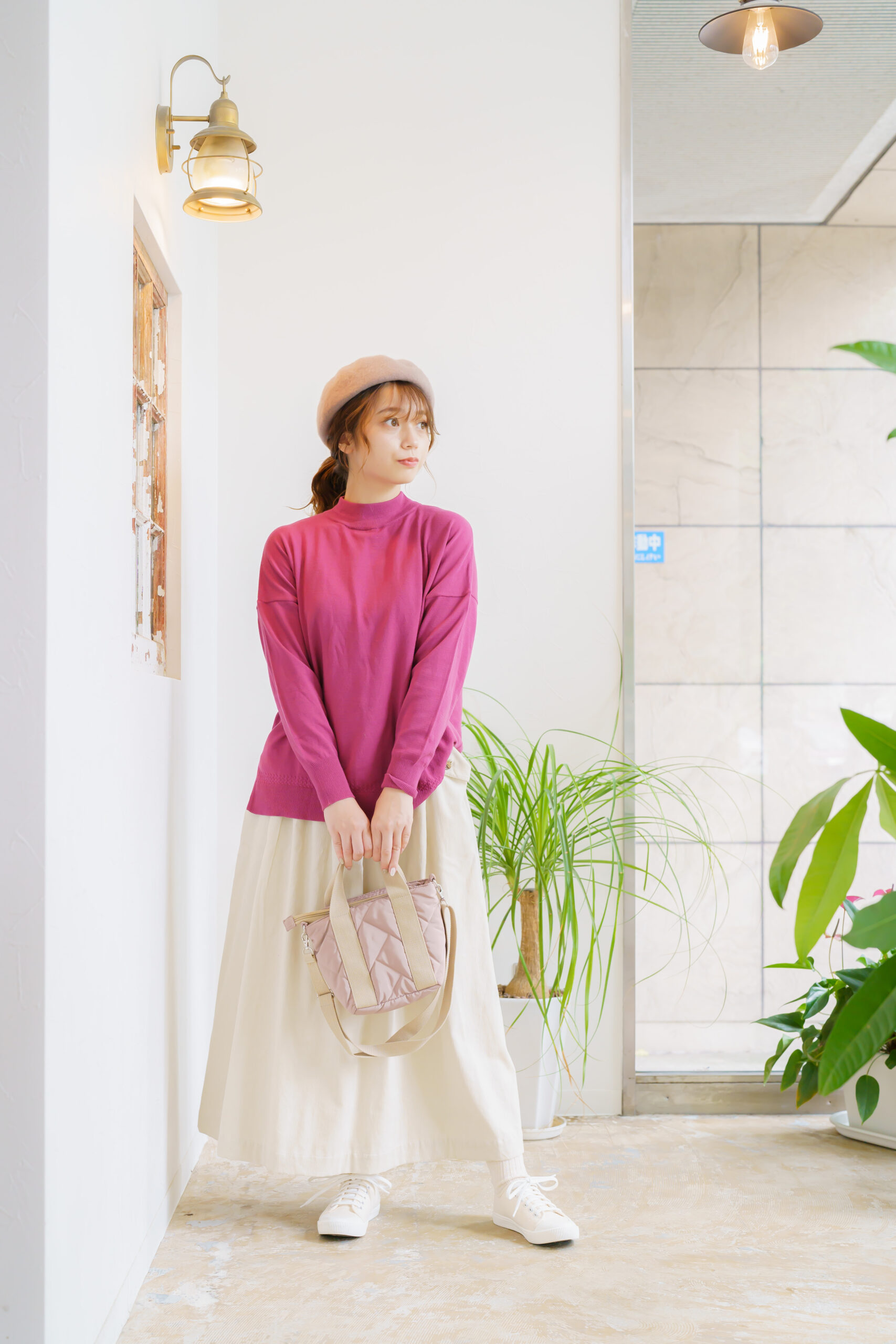ピンク色のニットを着た女性モデル写真