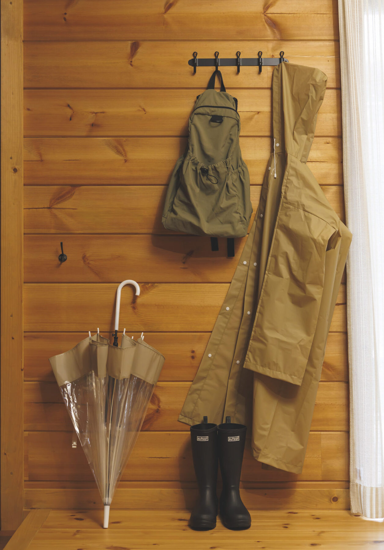 傘とレインコートとレインブーツとリュックの画像